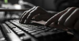 closeup of hands typing on keyboard