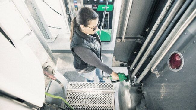 Female truck driver fills her tank