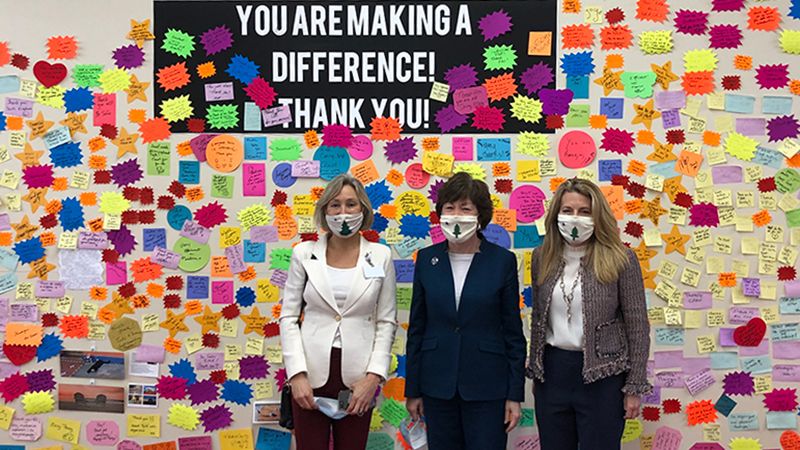 MaineHealth Chief Government Affairs Officer Katie Fullam Harris, Maine Senator Susan Collins and WEX CEO Melissa Smith at the Scarborough Downs COVID Clinic in Front of the Gratitude Wall