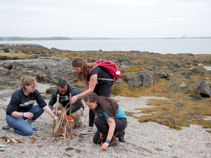 Group of interns working together to light a fire