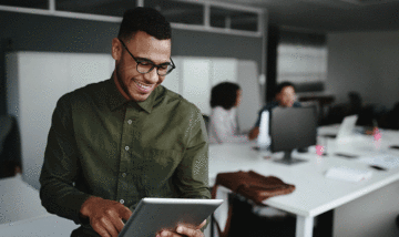 Smiling businessman scrolling on tablet