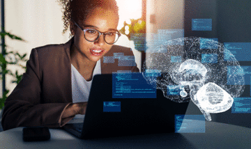 Woman using laptop with brain graphic overlay