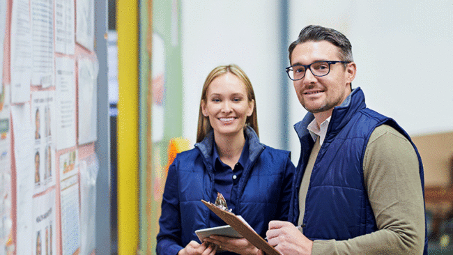 Suppliers holding a clipboard, looking happy